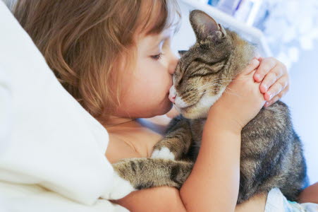 Petite fille embrassant son chat