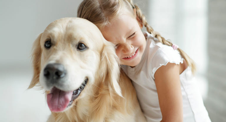 Petite fille faisant un câlin à un chien